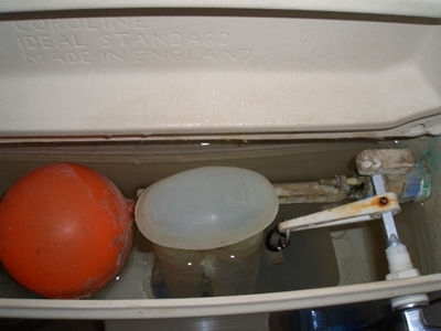 Cómo quitar la tapa de la tapa de la cisterna del inodoro