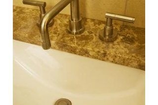 Cum să curățați petele de apă în afara unui robinet de bronz frecat cu ulei