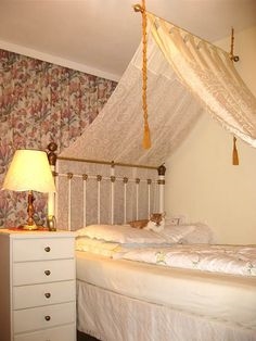 Cómo colgar cortinas en una cama con dosel