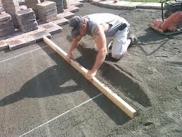 Cómo nivelar piedra triturada para un patio