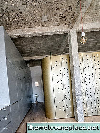 Uma cabine independente de ouro abriga quartos extras neste loft industrial