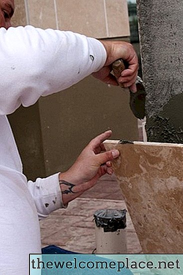 Come rimuovere l'adesivo per piastrelle dal muro a secco