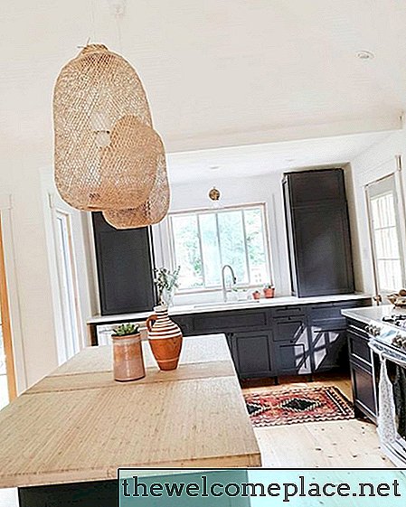Šilta mediena ir vėsios juodos spalvos sukuria dinamišką virtuvės dizainą